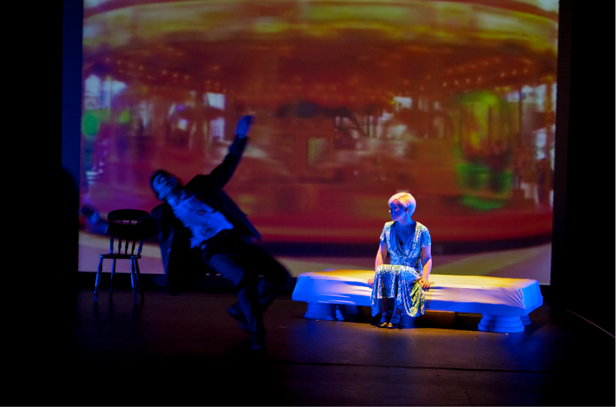 A man is falling on the ground while a woman is sitting behind looking in the abyss