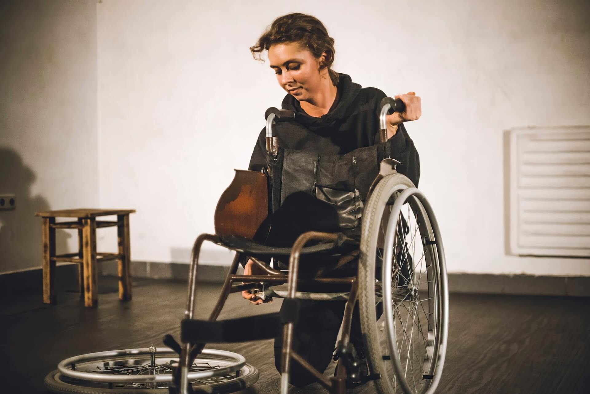 A performer is fixing a wheelchair.
